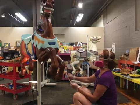 a woman working on a horse statue