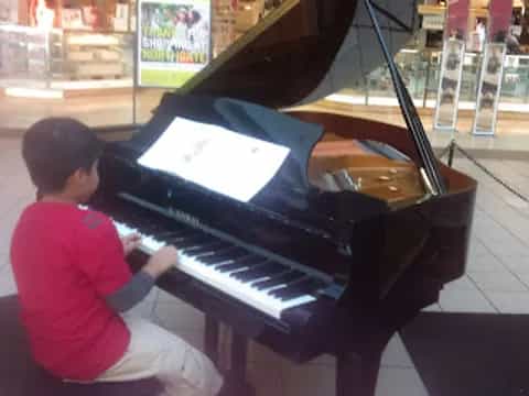 a boy playing a piano