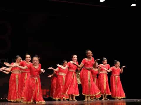 a group of women in red dresses