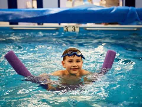 a boy in a pool with a dolphin