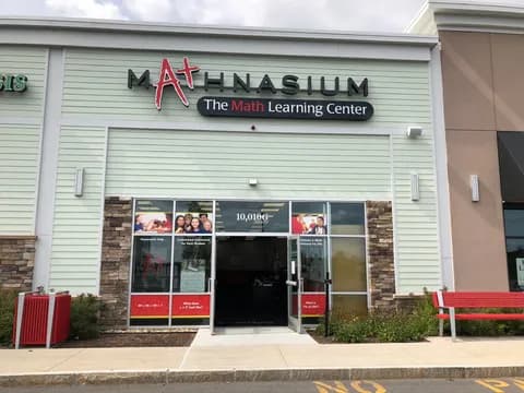 a store front with a red bench