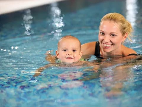 a person and a baby in a pool