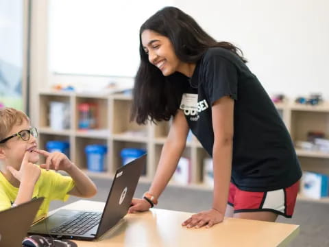 a person and a boy using laptops