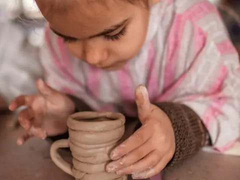 a baby holding a cup