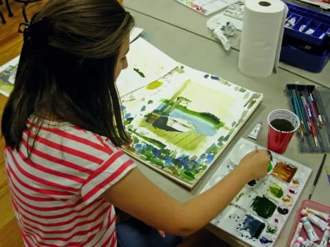 a woman painting on a table