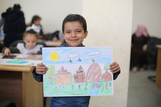 a boy holding a drawing