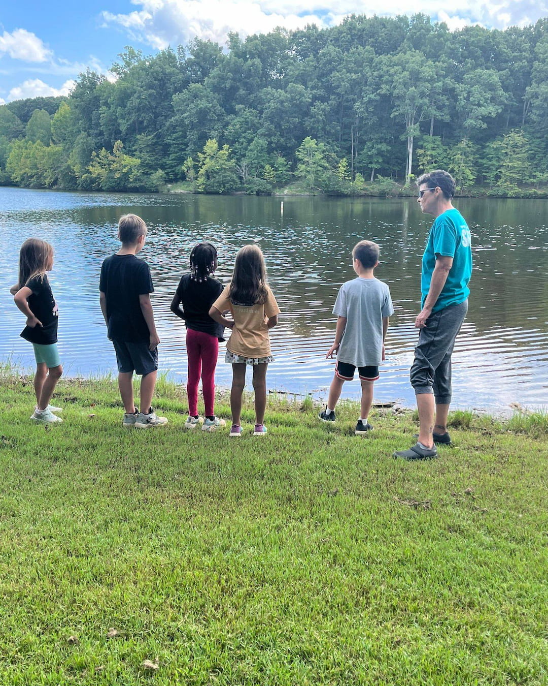 a group of people standing by a lake