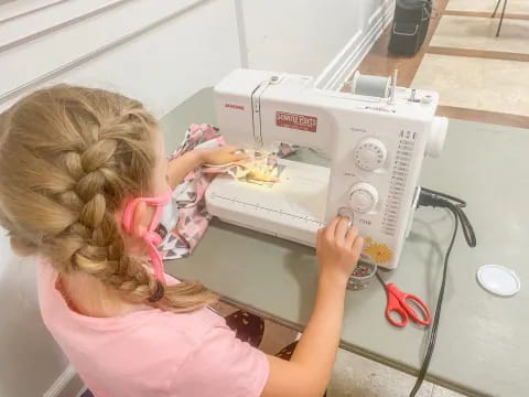 a girl using a sewing machine