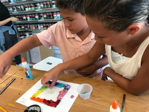 a couple of kids cutting a cake