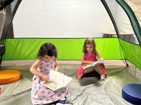 two girls sitting on the ground