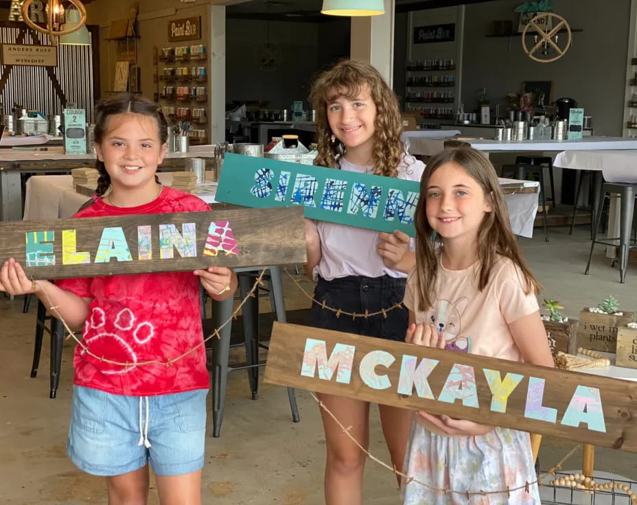 a group of girls holding a sign