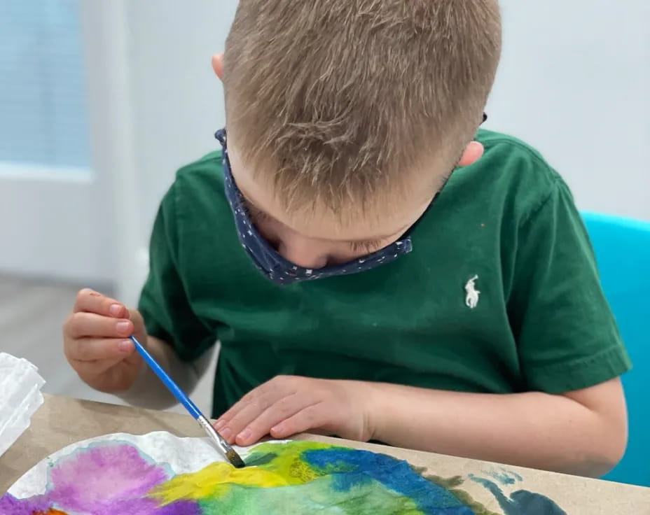 a boy painting on a table