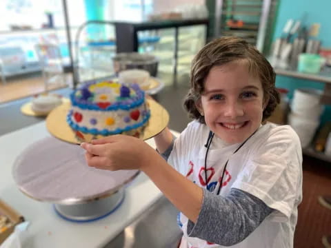 a girl holding a cake