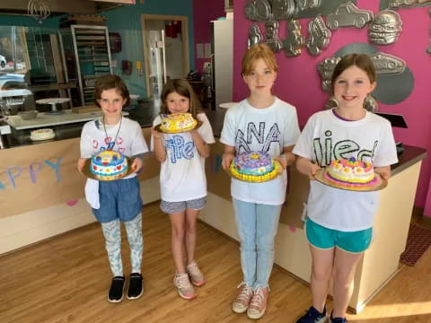 a group of children holding cake