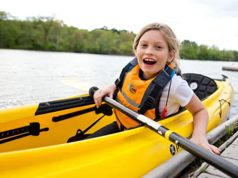 a child in a yellow kayak