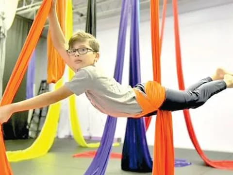 a boy jumping over a bar