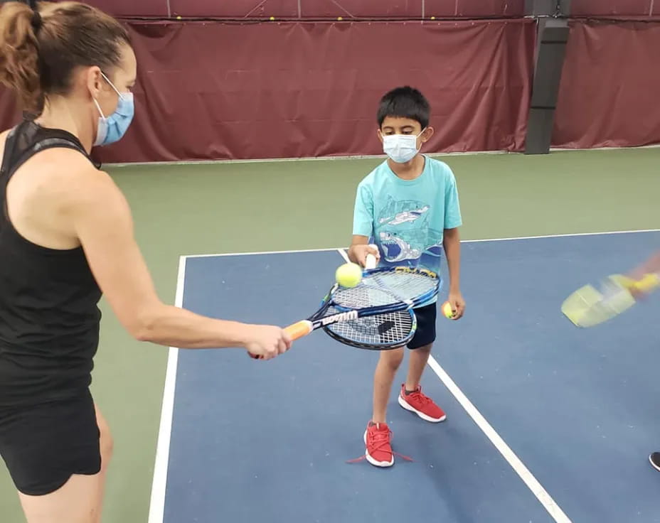 a woman and a boy playing tennis
