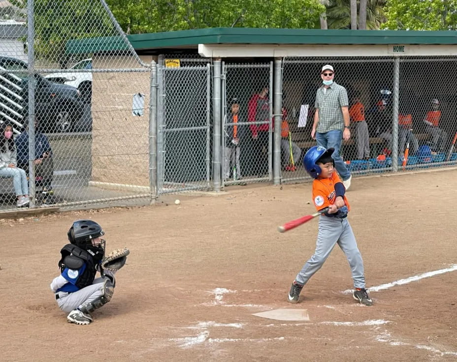 a kid swinging a baseball bat