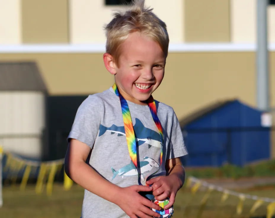 a boy smiling and holding a toy