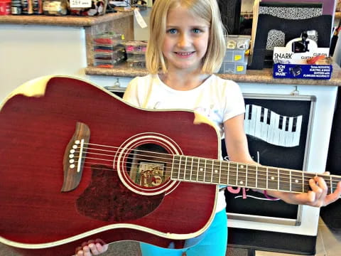 a girl holding a guitar