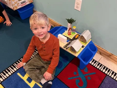 a boy sitting on a rug