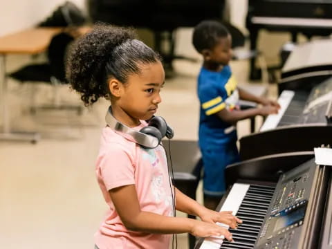 a young girl playing a piano