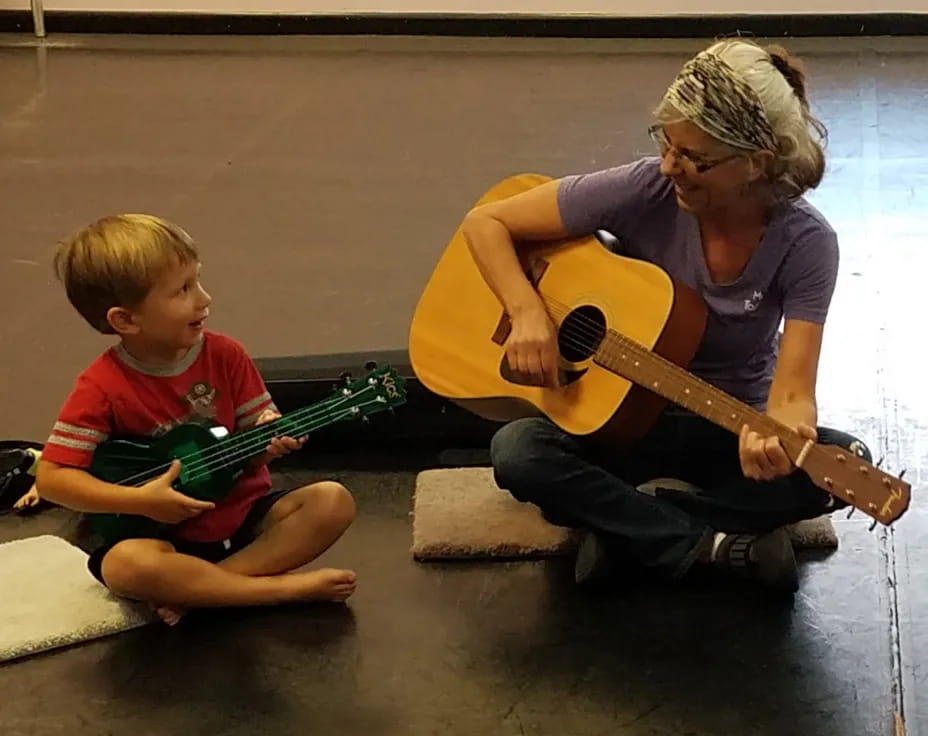 a person and a child playing guitar