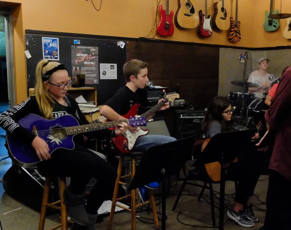 a group of people playing guitars