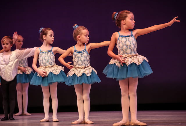 a group of girls in blue dresses