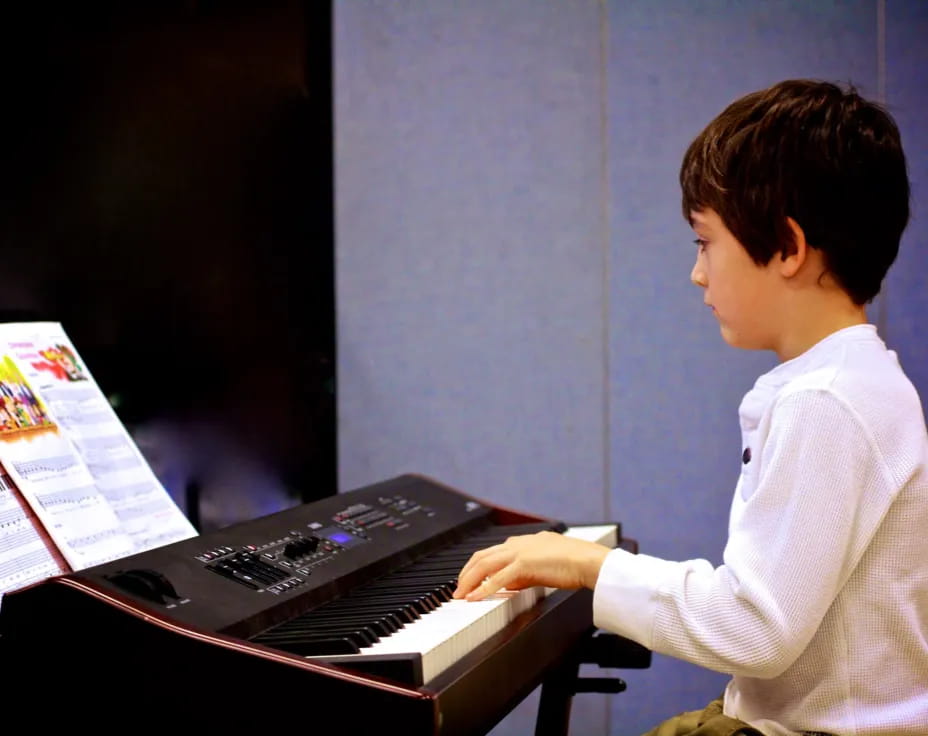 a young boy playing a piano