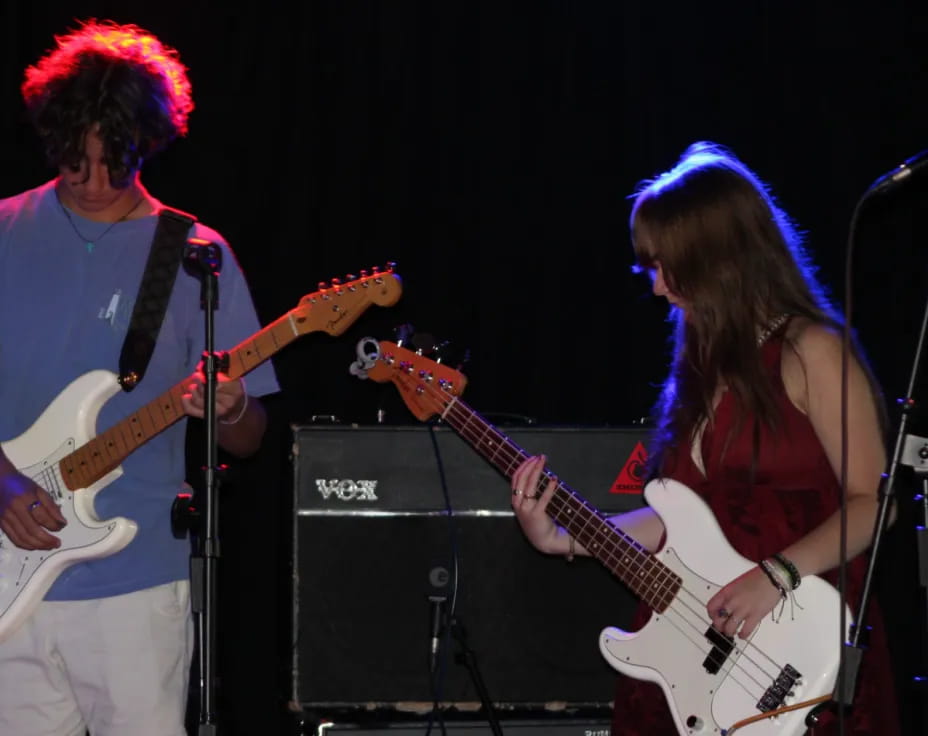 a man and woman playing guitars