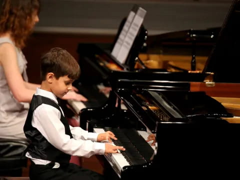 a person and a boy playing piano