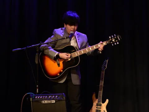 a man playing a guitar on a stage