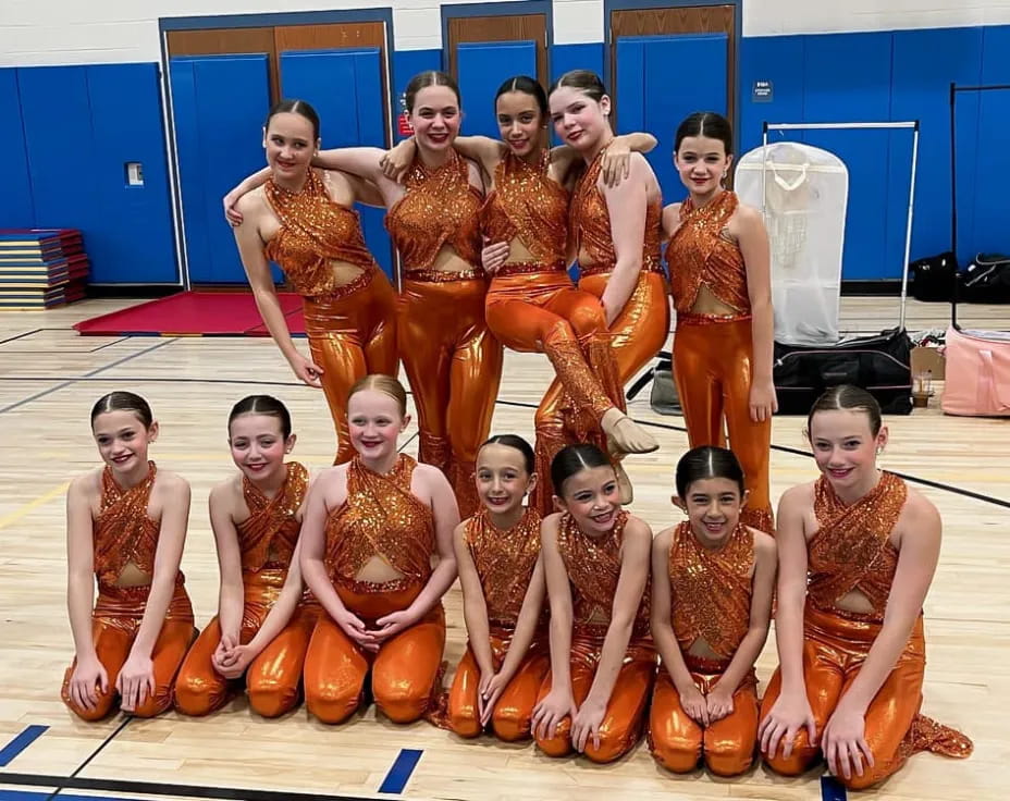 a group of women in orange dresses