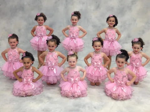 a group of girls in pink dresses