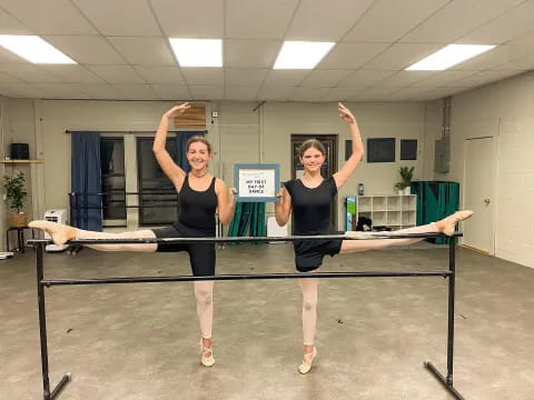 two women in black leotards