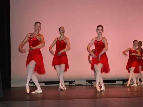 a group of women in red dresses