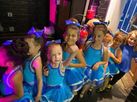 a group of girls in blue dresses