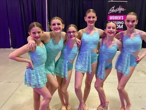 a group of women in blue dresses