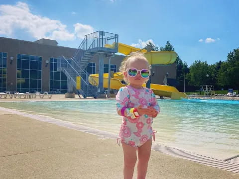a girl standing by a pool