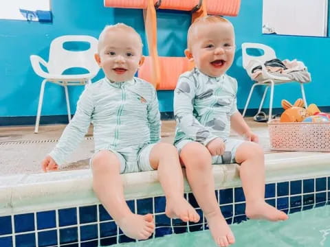 two babies sitting on a chair