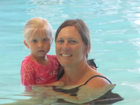 a woman and a baby in a pool