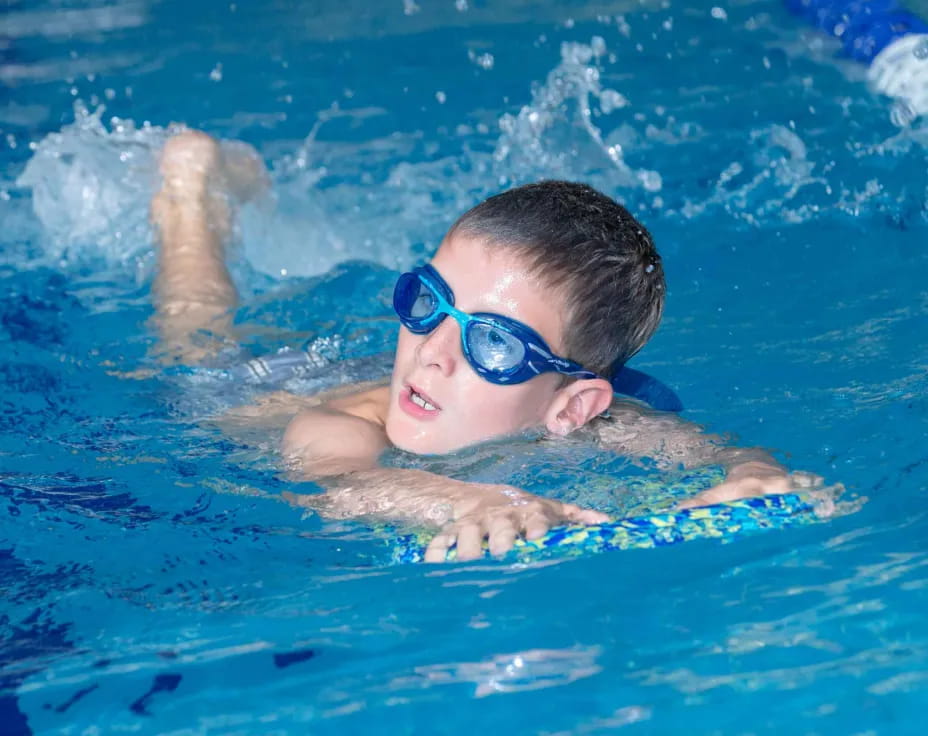 a boy swimming in a pool