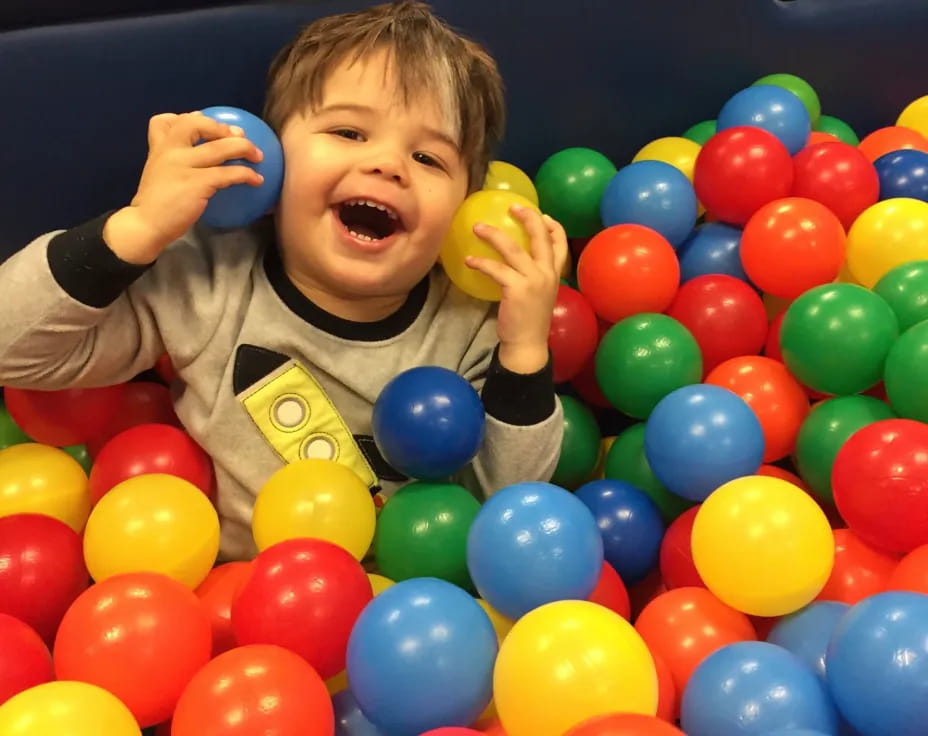 a boy in a ball pit