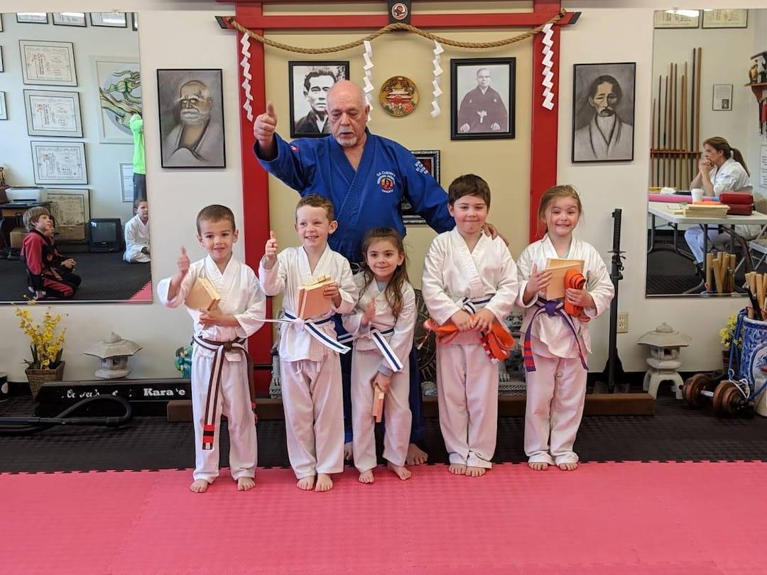 a group of children in karate uniforms