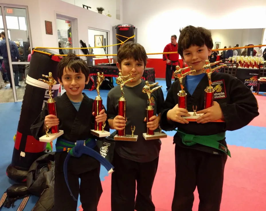 a group of boys holding trophies