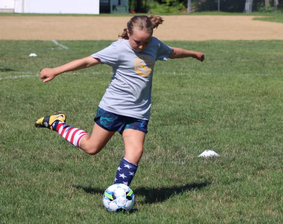a girl kicking a football ball