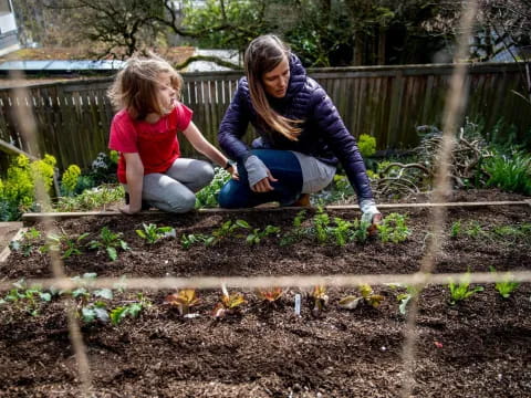 a man and a child planting plants