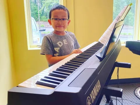 a boy sitting at a piano