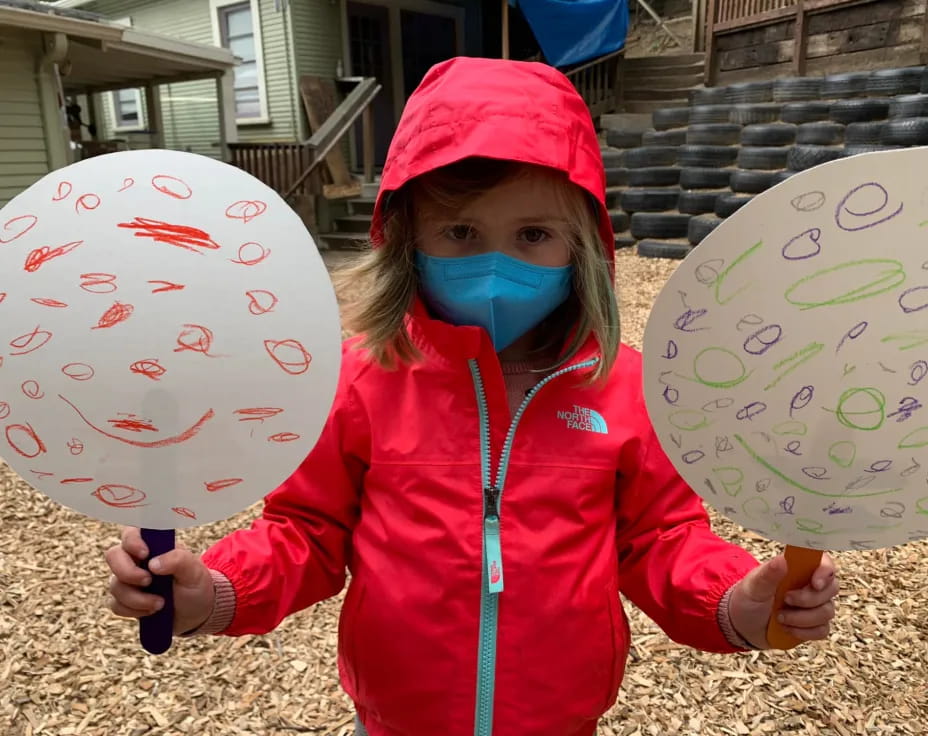 a girl holding a drawing